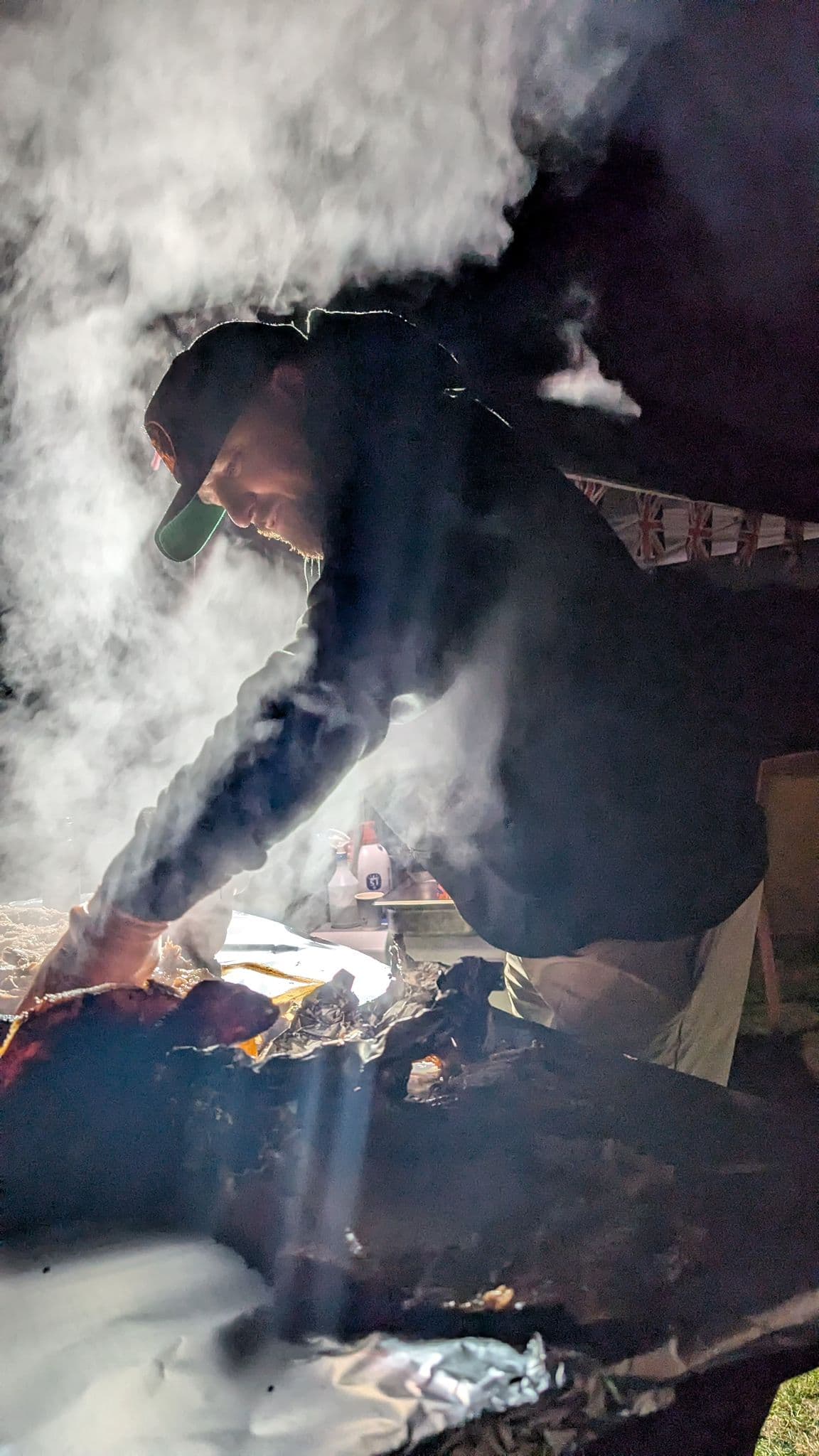 Meat Freaks pitmaster working the smoke at a night event
